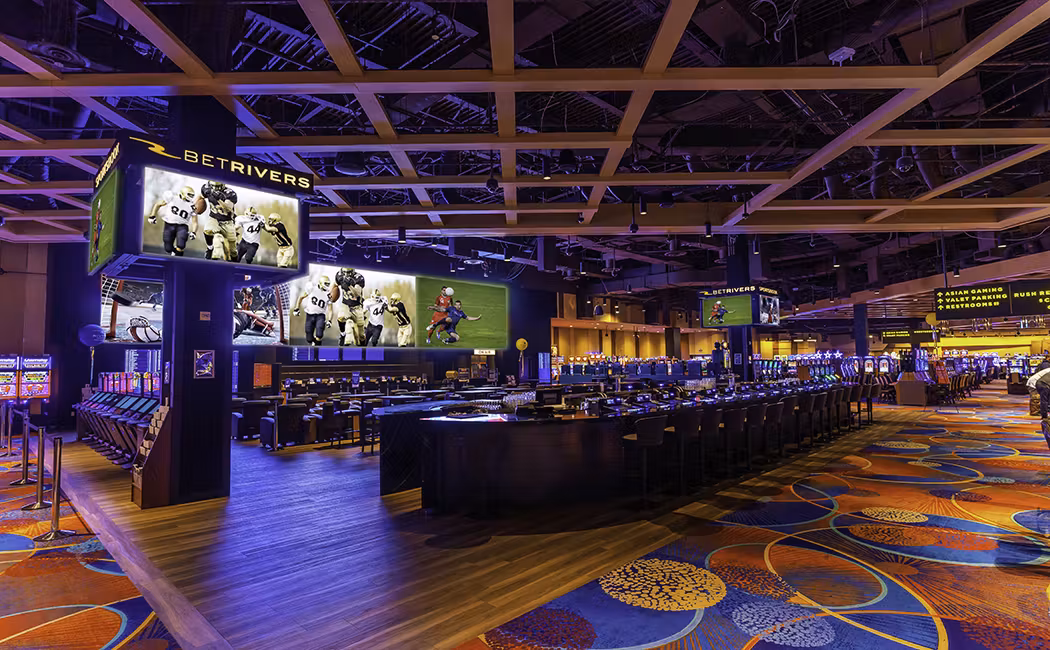 The luxurious sports bar at bet rivers casino including huge bonus on table games and slot games. Large flat screen TVs adorn the sports bar with ample seating and vibrant colors on the carpets and walls