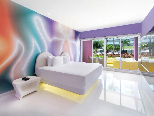Luxurious master suite at Temptation Cancun Resort with modern décor, king-size bed, ambient lighting, and ocean view balcony.