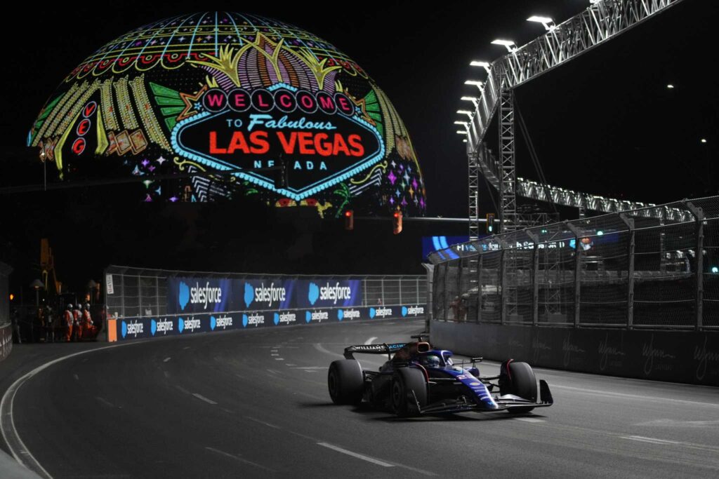 Formula 1 car racing under the iconic “Welcome to Fabulous Las Vegas” sign during the F1 Las Vegas 2025 night race.