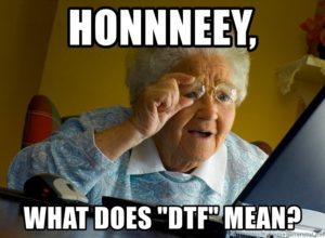 A meme featuring a close-up photo of an older woman looking intensely at a laptop screen through a magnifying glass she's holding up to one eye. The text overlaid on the image reads, in all caps: "HONNNNEEY, WHAT DOES DTF MEAN?"