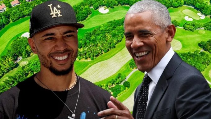 A composite digital graphic featuring Los Angeles Dodgers player Mookie Betts and former President Barack Obama. Betts is on the left wearing a black "LA" baseball cap and a black t-shirt, while Obama is on the right in a white dress shirt and dark patterned tie. Both men are smiling broadly. The background is a bright, saturated aerial view of a lush green golf course with winding fairways and sand traps.