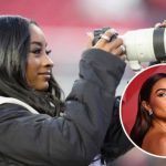 Olympic gymnast Simone Biles smiles while looking through a professional Sony telephoto camera lens on the sidelines of Levi's Stadium. She is wearing a black puffer jacket and a white NFL media vest. An inset circle shows a glamorous portrait of Olivia Culpo.