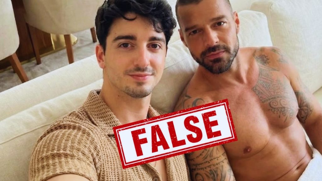 A side-by-side selfie of a spanish influencer and Ricky Martin lounging on a white sofa. Ricky Martin is shirtless, showing his chest tattoos, while a large red "FALSE" stamp is superimposed over the center of the image to indicate it is an AI-generated deepfake.