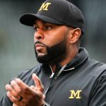News graphic announcing Sherrone Moore Suspended amidst online OnlyFans allegations, featuring a picture of the former coach.