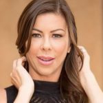 Headshot of Alexis Fawx with long brunette hair wearing a black sleeveless top.