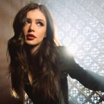 Musician Chrissy Costanza looking away from the camera in a professional portrait with soft backlighting.