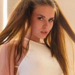 Portrait of Lauren Alexis, a rising independent filmmaker and actress, with pigtails wearing a white halter top.