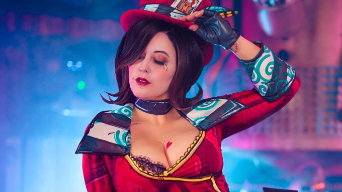 Meg Turney wearing a Mad Moxxi cosplay from the Borderlands video game series, featuring cel-shaded makeup and a red ringmaster outfit.