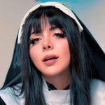 Close-up portrait of Momokun in a nun-inspired cosplay outfit featuring a black and white habit and veil with dark hair and bangs.