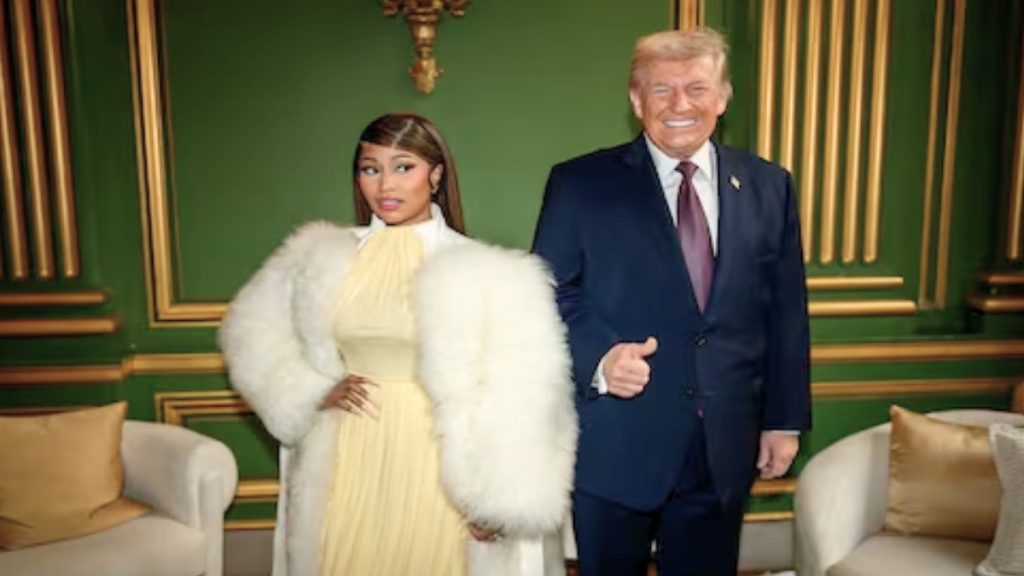 A medium shot of Nicki Minaj and Donald Trump posing together against a dark green wall with gold molding. Nicki Minaj is on the left, wearing a high-necked pale yellow dress and a large, voluminous white faux-fur coat. Donald Trump is on the right in a navy blue suit and red tie, giving a thumbs-up. Two cream-colored armchairs with gold pillows are visible in the foreground.