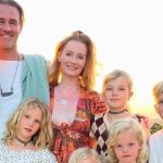 A warm family photo of James Van Der Beek, his wife Kimberly, and their six children posing outdoors under large oak trees. James is smiling while one daughter sits on his shoulders. The image is associated with news regarding a James Van Der Beek GoFundMe and the family’s move to a $4.76M ranch in Texas.
