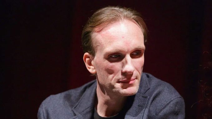 A thumbnail for a video titled "Peter Greene Cause of Death: Accidental Gunshot Revealed." The image features a large, somber headshot of Peter Greene. Next to him is an illustrative graphic of a human torso with a highlight on the "left axilla" (armpit area) where the medical examiner confirmed the fatal wound occurred.