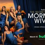 The official promotional poster for The Secret Lives of Mormon Wives features eight cast members posed together against a dramatic backdrop of blue curtains. The women are all dressed in various shades of vibrant blue gowns, surrounded by clusters of orange marigolds. The background reveals a sunset over a mountain range and a field of flowers. Text on the poster reads "hulu THE SECRET LIVES OF MORMON WIVES," "DRAMA SPRINGS ETERNAL," and lists a release date of "March 12" on Hulu and Disney+.
