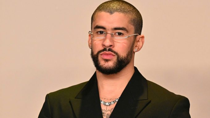 Bad Bunny birthday celebration portrait featuring Benito in a sleek black suit, silver rimless glasses, and a diamond chain.