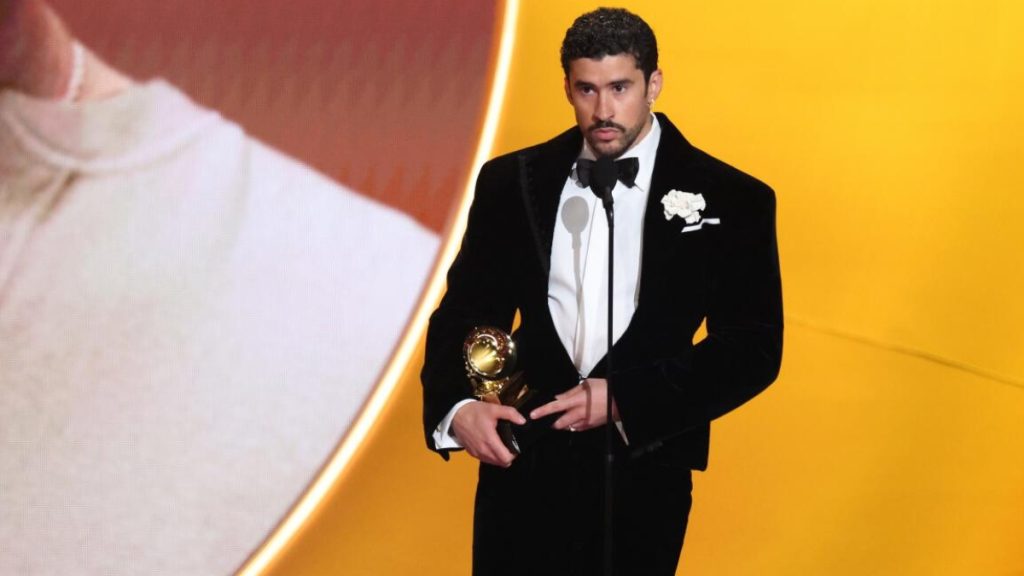 Artist Bad Bunny holding a microphone during a live performance, featured in news coverage regarding the Bad Bunny birthday in 2026.