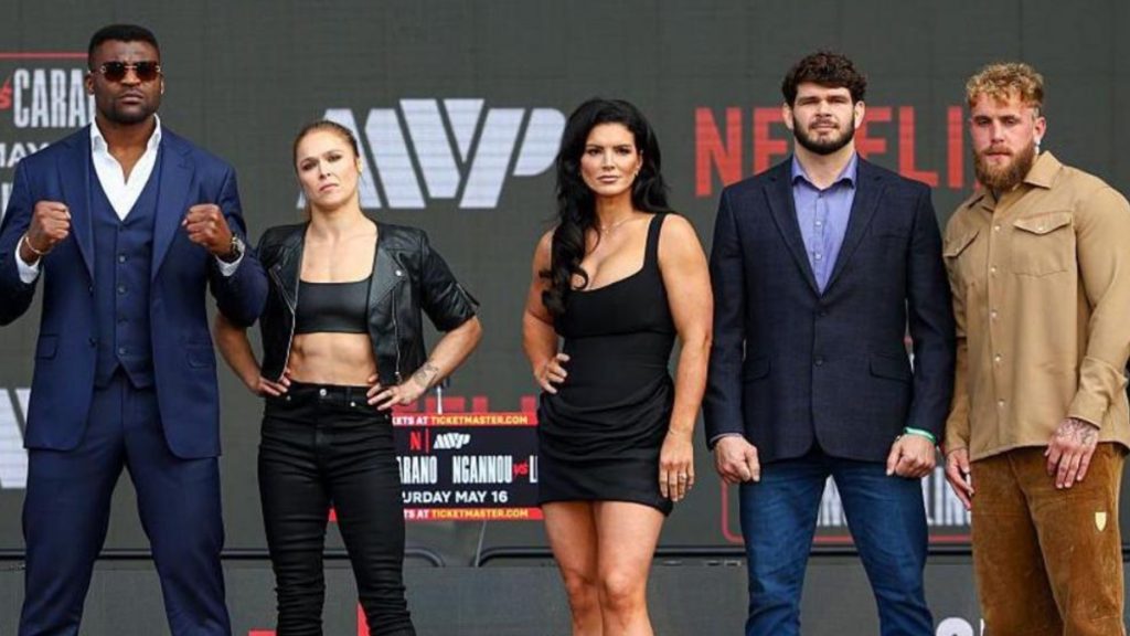 Promotional graphic for the Gina Carano vs Ronda Rousey epic fight night, featuring high-contrast portraits of both fighters. The text highlights the May 16, 2026 date and the live global broadcast on Netflix.