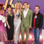 A full-length photo of a group of six posing against a purple wall at the Hannah Montana Reunion event.