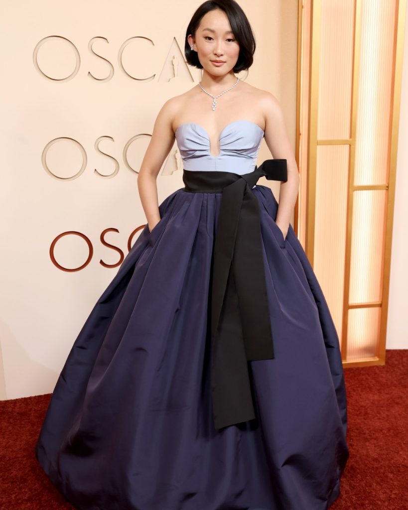 Ji-young Yoo posing in a voluminous and elegant Carolina Herrera gown on the Oscars Red Carpet 2026.