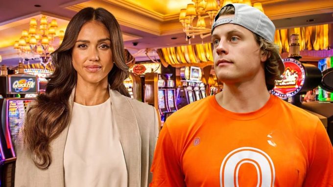 A bright composite image of Joe Burrow Jessica Alba in a Las Vegas casino setting. Jessica Alba stands on the left wearing a white top and tan blazer, looking toward the camera. Joe Burrow is on the right, wearing an orange t-shirt and a grey baseball cap worn backward, looking off-camera. Slot machines and glowing casino chandeliers are visible in the background.