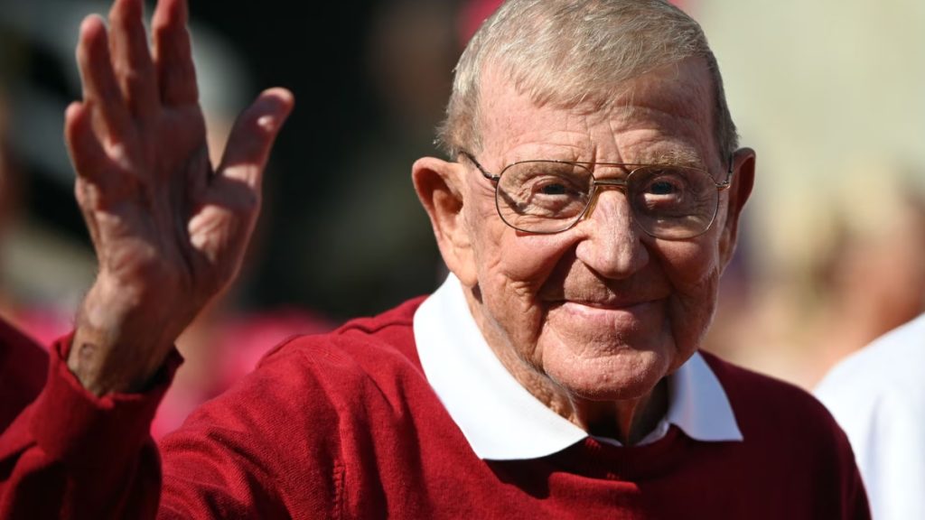 Lou Holtz waving his hand towards camera 