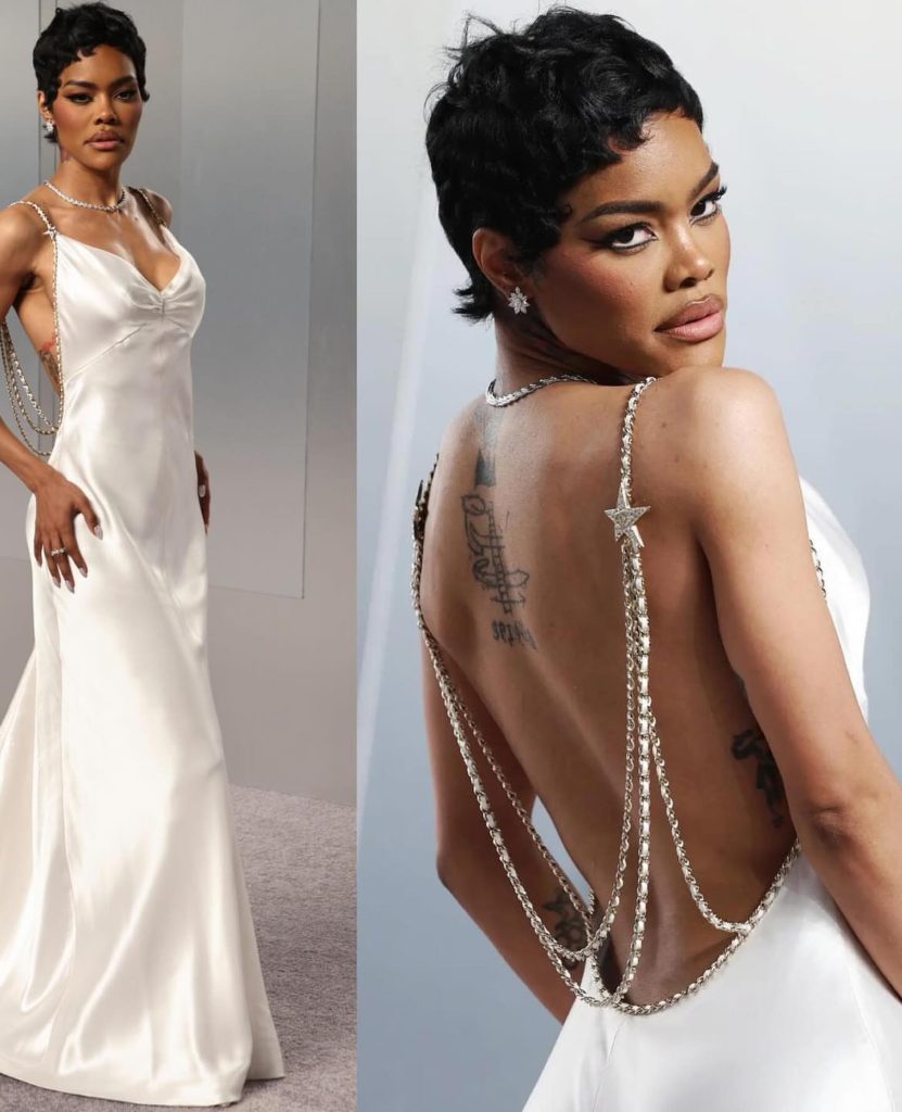 A detailed view of Teyana Taylor’s open-back white slip dress with cascading chain straps and a star detail