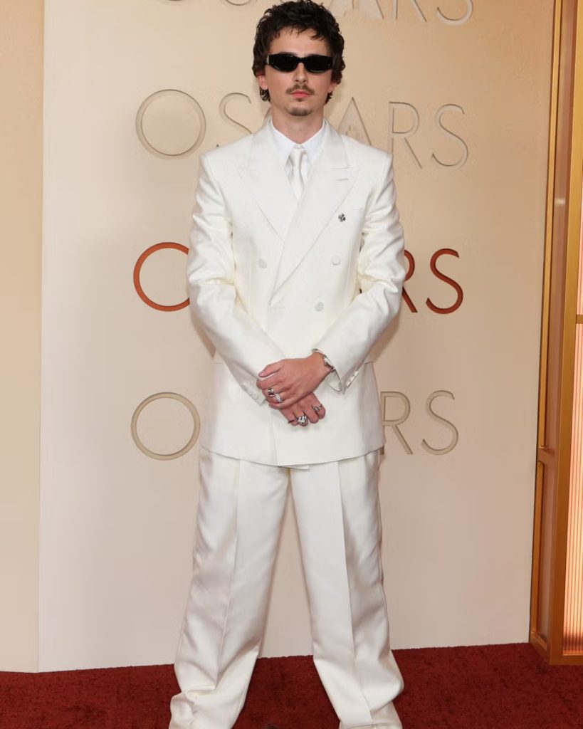  Timothée Chalamet wearing an edgy, shirtless look with a sequined black cropped blazer and slim-fit leather trousers.