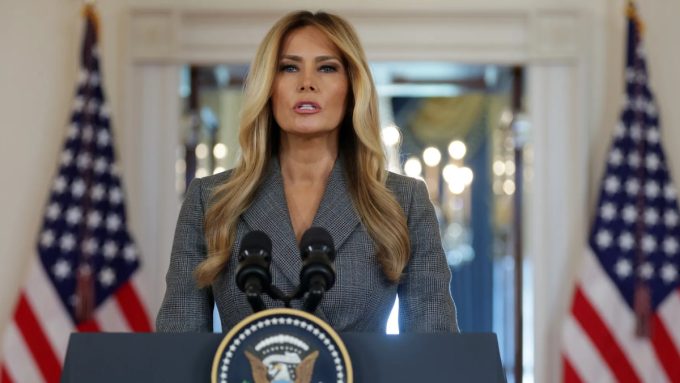 A news-style graphic featuring a photo of Melania Trump looking directly at the camera. Overlaid text reads, "Melania Trump Denies Close Ties in Rare Statement" regarding public speculation.