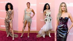 A collage of four artists at the Billboard Women in Music 2026 red carpet: Tyla in a brown feathered mini-dress with a long side-train. Host Keke Palmer in a silver beaded fringe one-shoulder mini-dress. Teyana Taylor in a cream-colored sculptural corset dress with an ethereal tulle skirt. Tate McRae in a strapless black patent leather midi-dress.