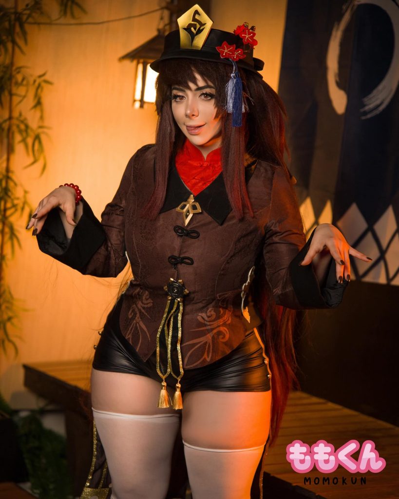 Mariah Mallad in a Hu Tao cosplay from Genshin Impact, wearing a brown patterned coat, black shorts, and a signature decorated hat.