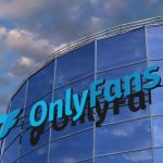 The OnlyFans logo mounted on a modern glass office building under a blue sky with clouds, representing the platform's growth following the Architect Capital deal.