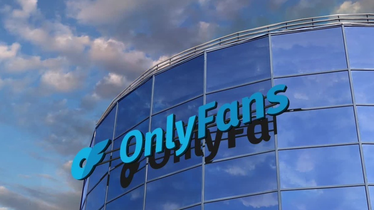 The OnlyFans logo mounted on a modern glass office building under a blue sky with clouds, representing the platform's growth following the Architect Capital deal.