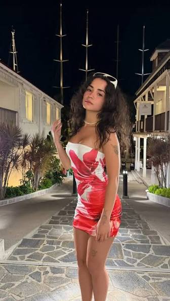 Full-length evening shot of Jameliz Benitez Smith posing outdoors at night on a stone path, wearing a tight, strapless red and white abstract print dress. Exclusive evening looks are featured on her No PPV OnlyFans.