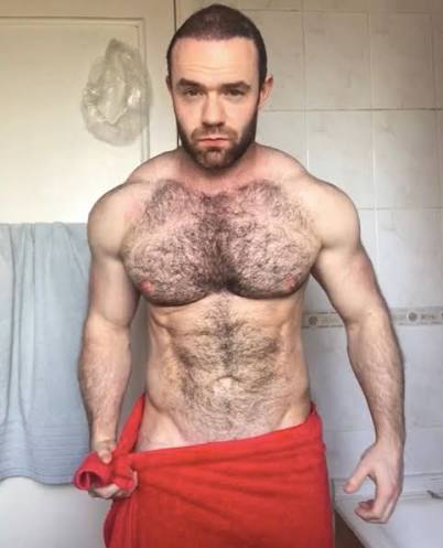 Irish OnlyFans creator Jay Cottz posing in a bathroom wrapped in a red towel.