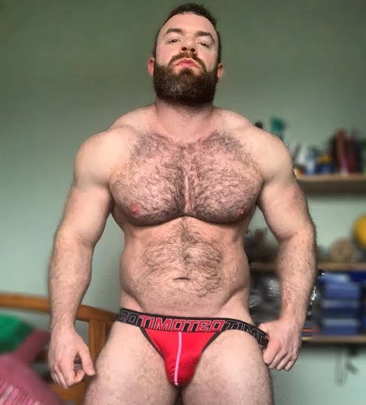 Irish OnlyFans model Jay Cottz standing in red athletic briefs.
