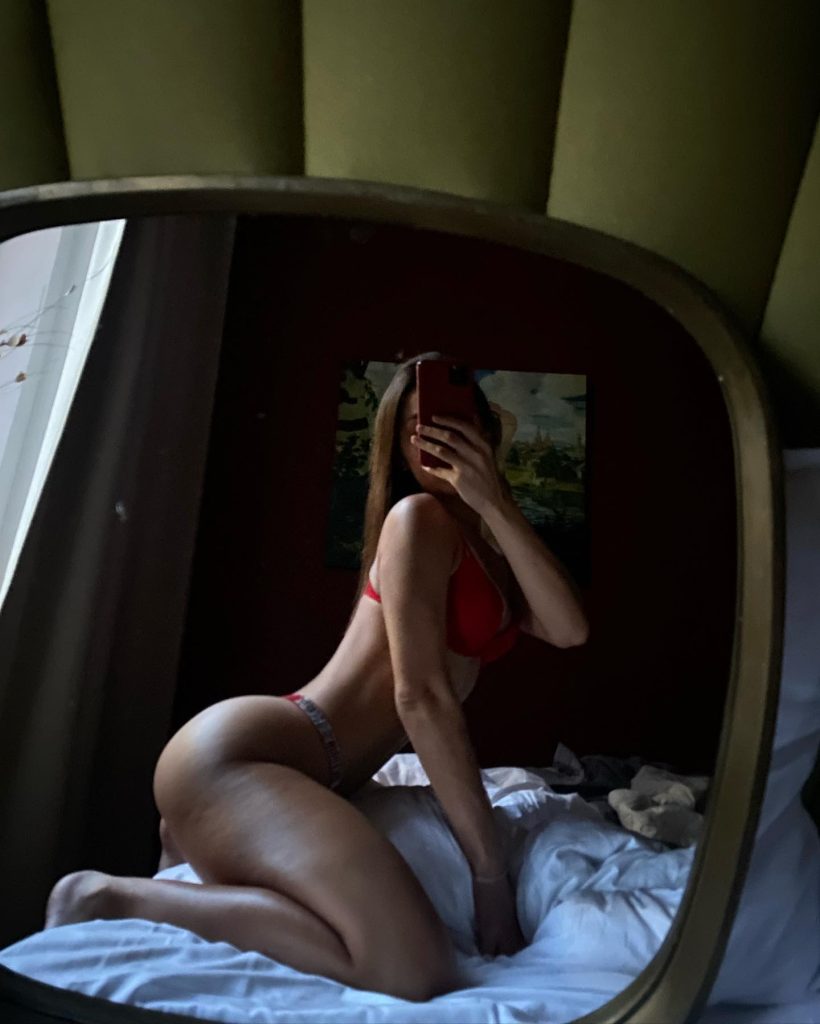 Dutch Onlyfans creator Ellie Leen taking a mirror selfie while wearing a dark-colored top