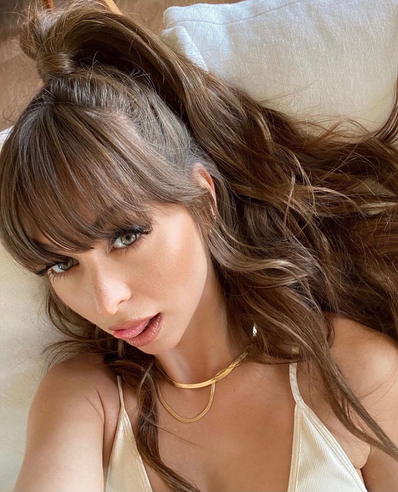 A close-up portrait of content creator Riley Reid looking at the camera with her hair in a high ponytail and bangs, perfect for a Riley Reid OnlyFans biography update.