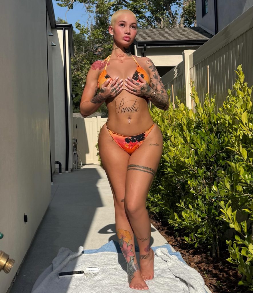 Full-length shot of Bhad Bhabie posing outdoors in an orange tropical bikini for Lightskin OnlyFans content.