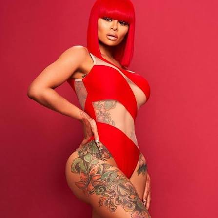Blac Chyna, a prominent Thick OnlyFans creator, posing in a red cut-out bodysuit against a matching red backdrop.
