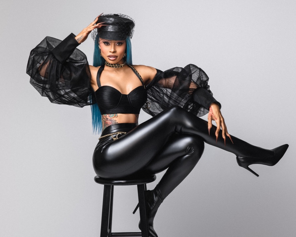 Blac Chyna posing in a black leather outfit with blue hair and a Chanel belt, featured in top Lightskin OnlyFans models list.