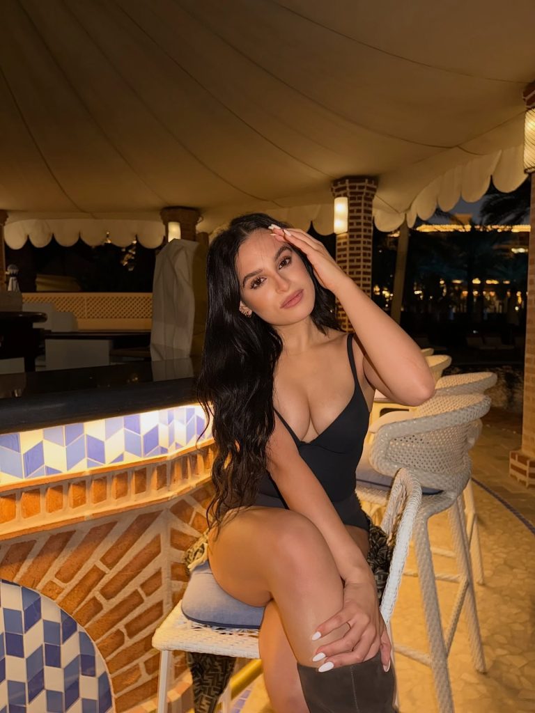 Cuban OnlyFans creator Cubanita sitting at an outdoor bar in a black top.