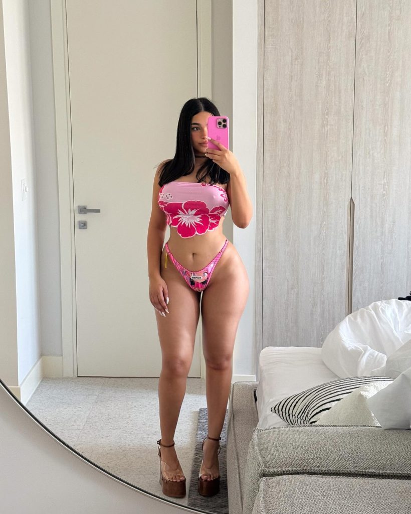 Leila Santese posing in a pink floral crop top outfit — Italian Big Ass OnlyFans creator.