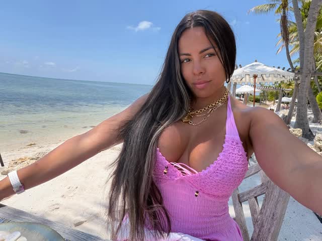 Cuban OnlyFans model Luna Star posing on a tropical beach in a pink crochet top.