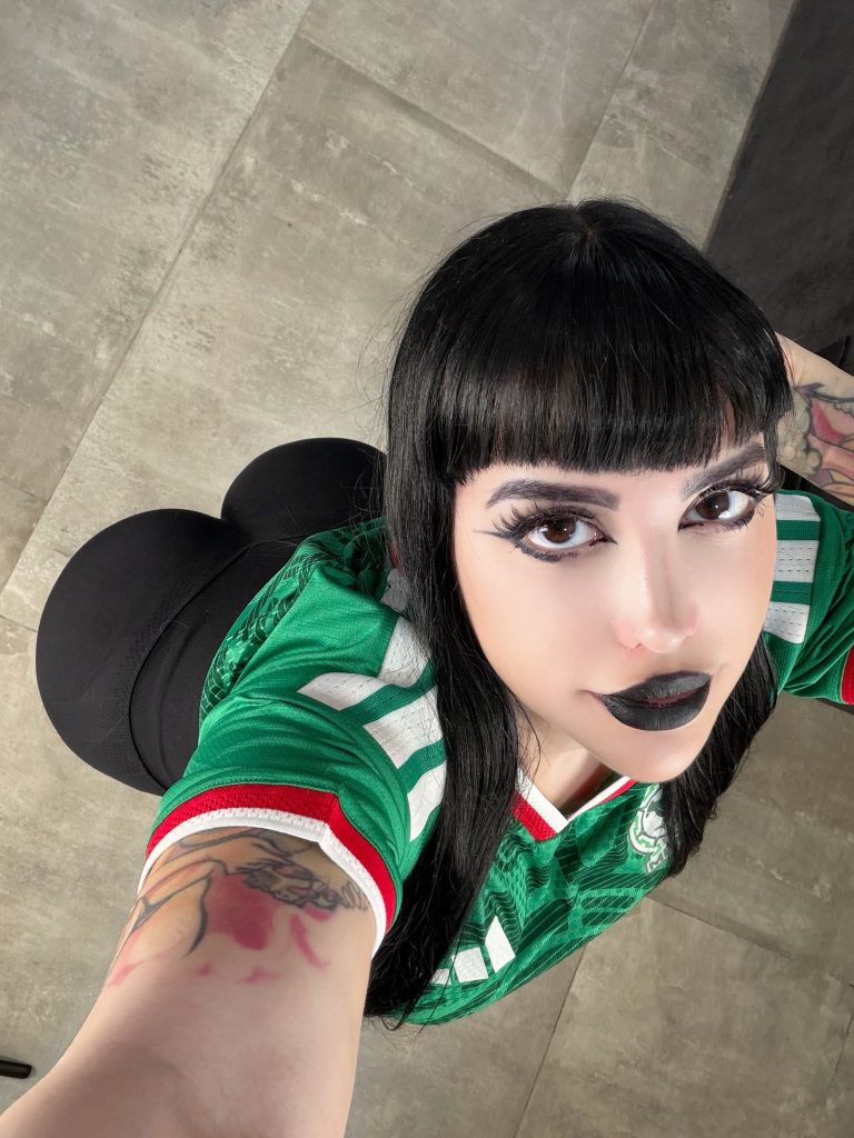 Micaela Ari taking a top-down selfie in a green jersey — Big Ass OnlyFans creator.