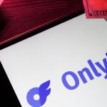 Tablet displaying the OnlyFans logo surrounded by US hundred-dollar bills, illustrating OnlyFans creator earnings AI concepts.