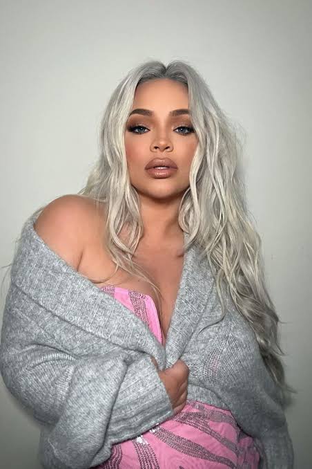 Trisha Paytas, an OnlyFans creator, posing in a grey cardigan over a pink top.