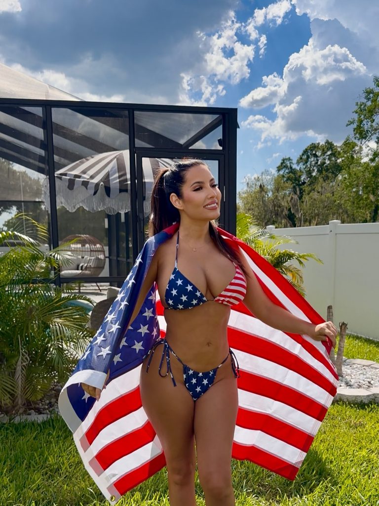 Yusi Dubbs posing in US flag wearing USA bikini
