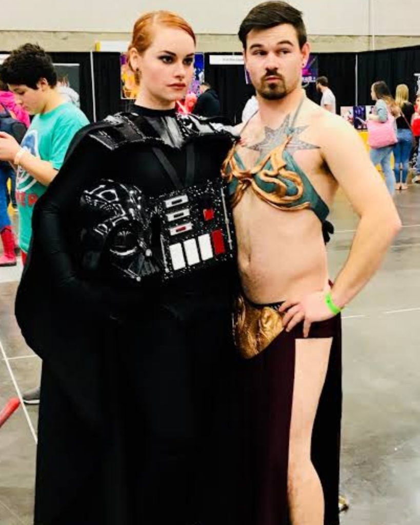 Two cosplayers in swapped Star Wars costumes featuring a female Darth Vader and male Slave Leia, highlighting top cosplay trends in gender-bent character designs
