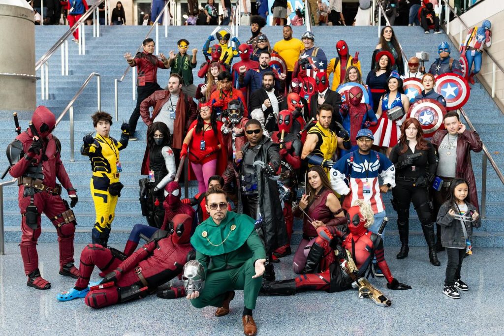 Dozens of Marvel cosplayers, including Deadpool and Captain America variants, posing on convention stairs, illustrating top cosplay trends in squad meetups.