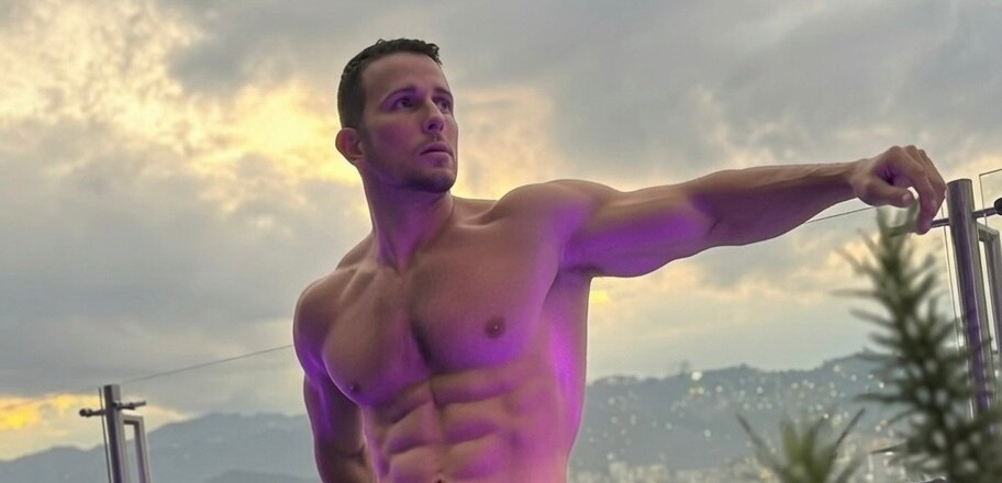 Muscular male model posing outdoors on a balcony at sunset — Best Male OnlyFans content
