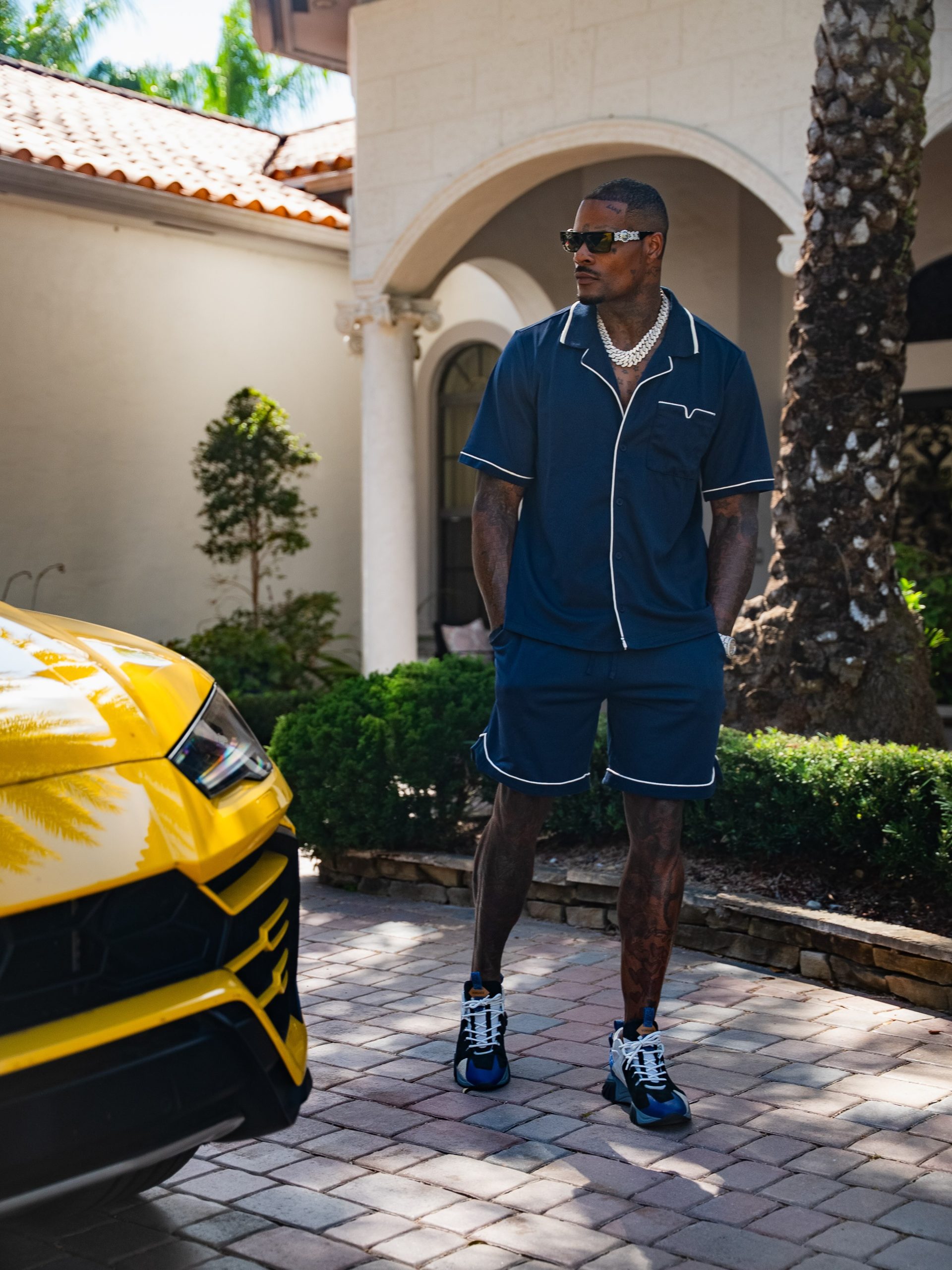 Stylish model standing next to a luxury car outdoors